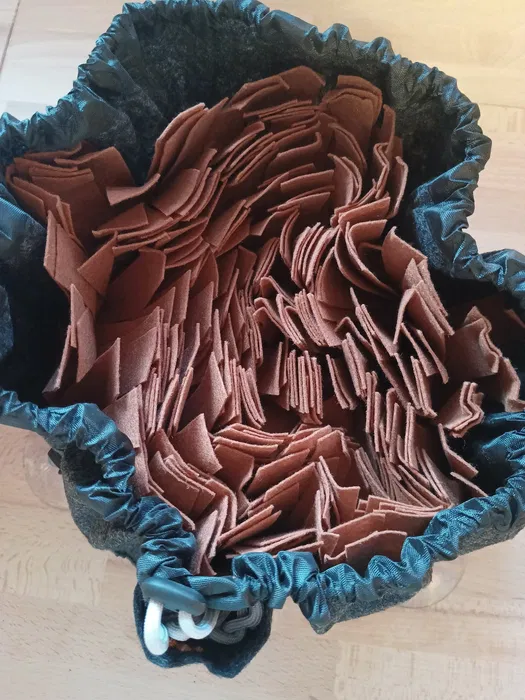 Szaro-brązowa okrągła mata węchowa dla psa Sunfatt o średnicy 30 cm obok fabrycznego kartonu