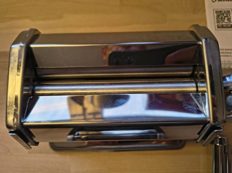 Biały karton z maszynką do makaronu Silvercrest Pasta Machine na drewnianym blacie