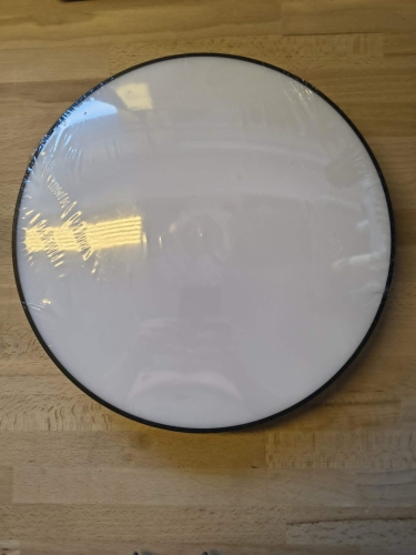 Czarna inteligentna lampa sufitowa LED plafon Smart Wi-Fi obok pilota i uszkodzonego kartonu