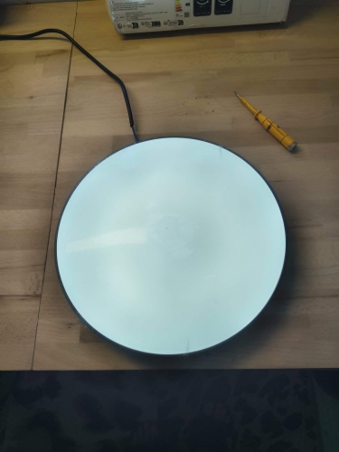Czarna inteligentna lampa sufitowa LED plafon Smart Wi-Fi obok pilota i uszkodzonego kartonu