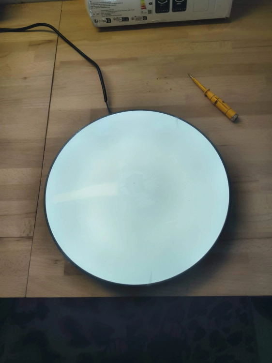Czarna inteligentna lampa sufitowa LED plafon Smart Wi-Fi obok pilota i uszkodzonego kartonu