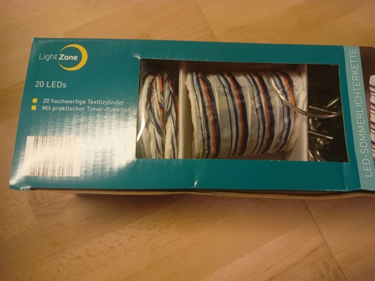 Turkusowy karton z łańcuchem świetlnym Light Zone 20 LED i grafiką lampionów w paski
