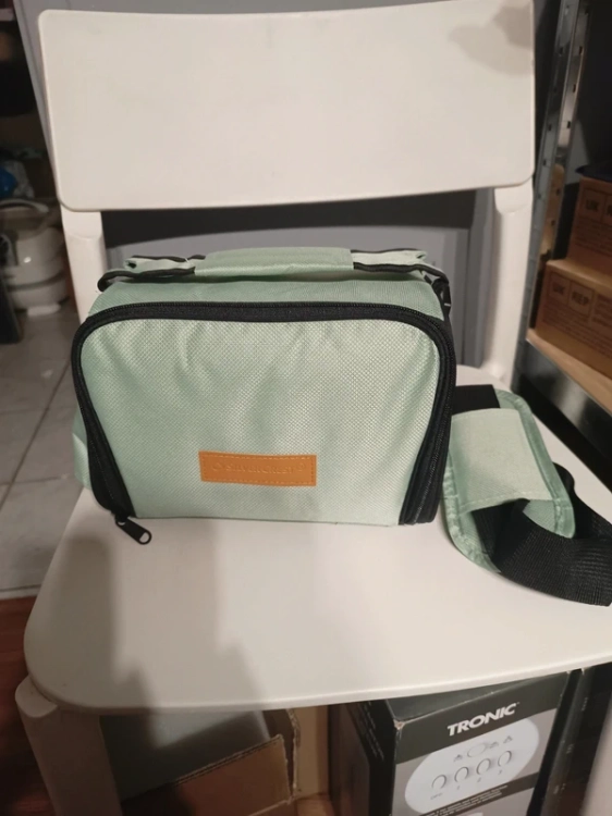 Miętowa materiałowa torba termiczna lunch box trzymana za górny szeroki pas