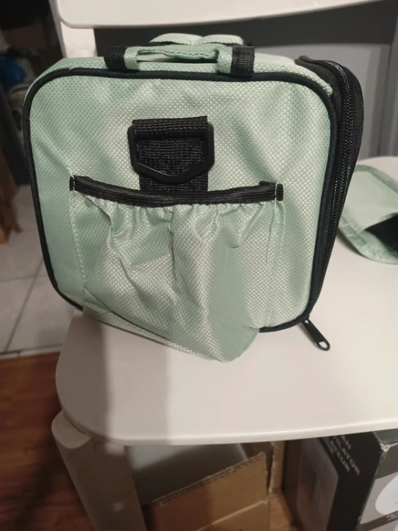 Miętowa materiałowa torba termiczna lunch box trzymana za górny szeroki pas