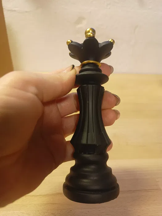 Nowoczesna czarna żywiczna figurka dekoracyjna w kształcie szachowej królowej o wysokości 14,5 cm na jasnym tle