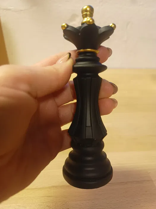 Nowoczesna czarna żywiczna figurka dekoracyjna w kształcie szachowej królowej o wysokości 14,5 cm na jasnym tle