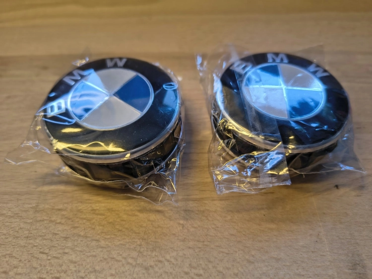 Nowe oryginalne dekielki kapselki do felg aluminiowych BMW o średnicy 56 mm z widocznymi numerami seryjnymi 6857149 na wewnętrznej stronie