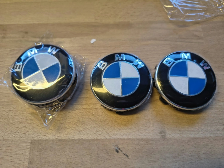 Nowe oryginalne dekielki kapselki do felg aluminiowych BMW o średnicy 56 mm z widocznymi numerami seryjnymi 6857149 na wewnętrznej stronie