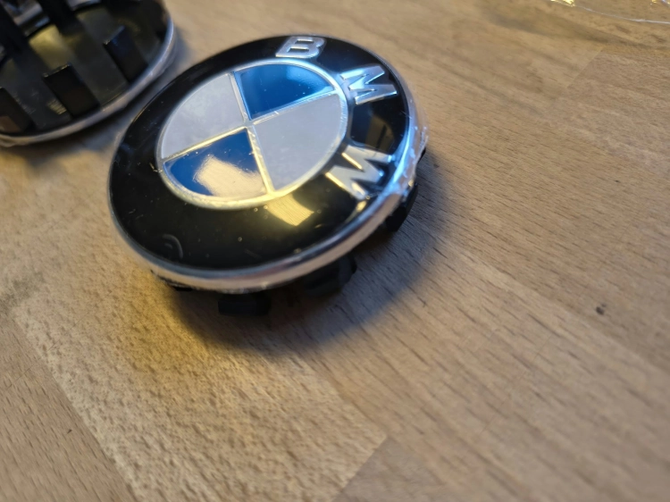Nowe oryginalne dekielki kapselki do felg aluminiowych BMW o średnicy 56 mm z widocznymi numerami seryjnymi 6857149 na wewnętrznej stronie