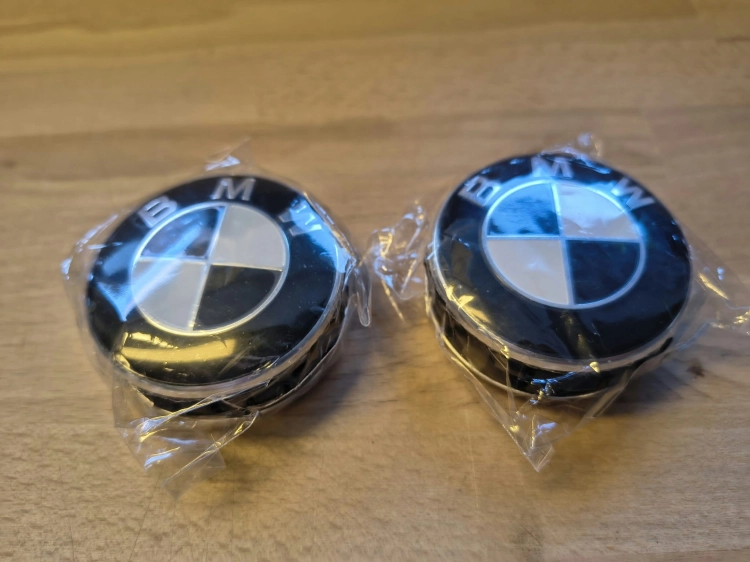Komplet 4 nowych oryginalnych dekielków kapselków do felg aluminiowych BMW o średnicy 56 mm w folii ochronnej z widocznym numerem seryjnym 6857149