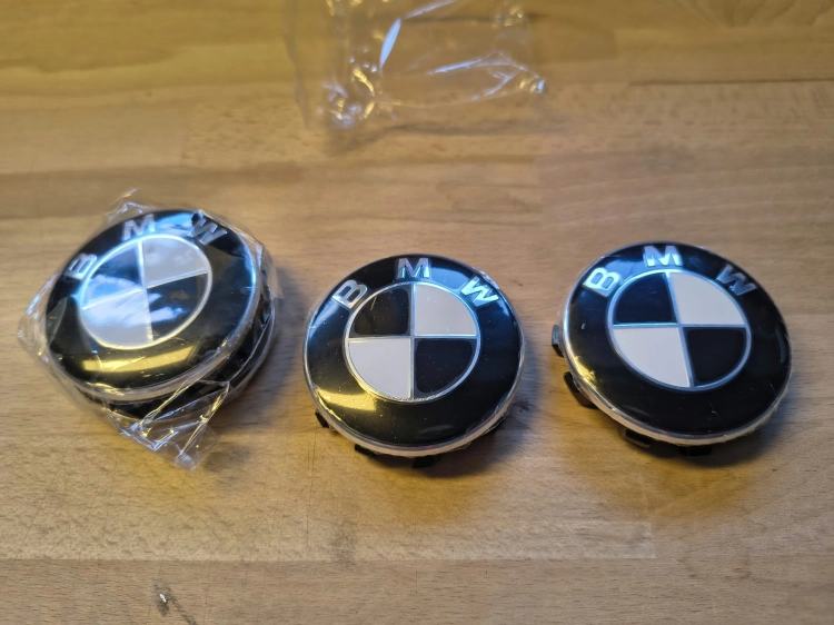 Komplet 4 nowych oryginalnych dekielków kapselków do felg aluminiowych BMW o średnicy 56 mm w folii ochronnej z widocznym numerem seryjnym 6857149
