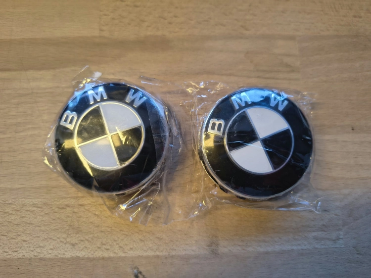 Komplet 4 nowych oryginalnych dekielków kapselków do felg aluminiowych BMW o średnicy 56 mm w folii ochronnej z widocznym numerem seryjnym 6857149