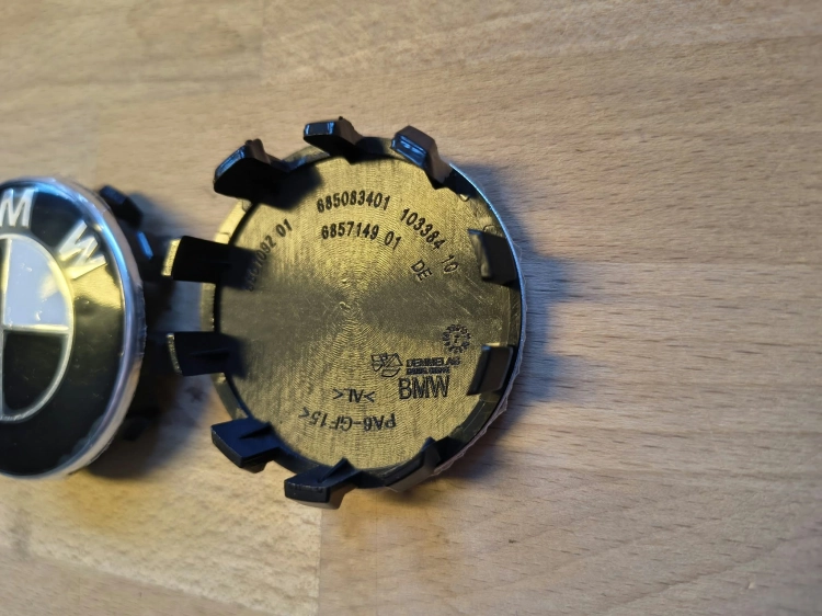 Komplet 4 nowych oryginalnych dekielków kapselków do felg aluminiowych BMW o średnicy 56 mm w folii ochronnej z widocznym numerem seryjnym 6857149