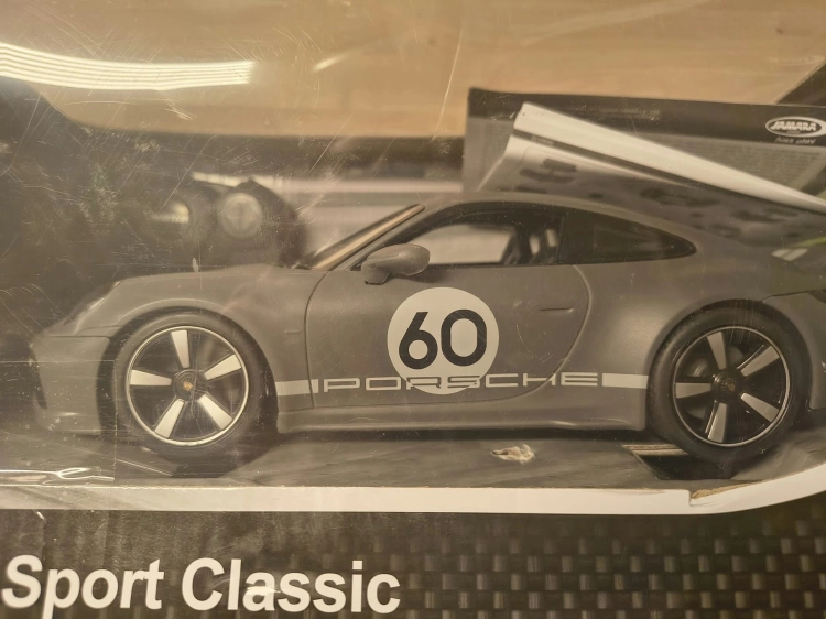 Nowe fabrycznie zapakowane szare zdalnie sterowane auto Porsche Sport Classic marki Rastar w skali 1 do 16 z widocznymi wgnieceniami na pudełku