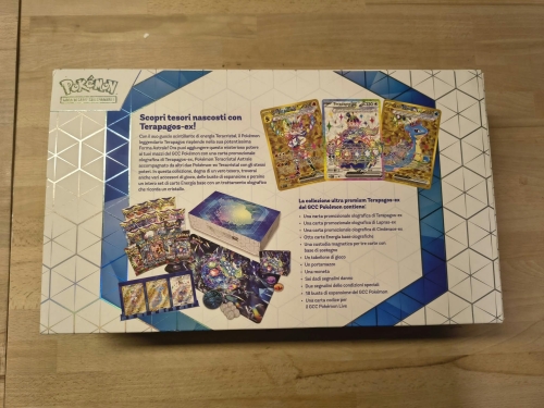 Nowy oryginalny zestaw Pokémon TCG Terapagos ex Ultra Premium Collection w języku włoskim z widocznym spisem zawartości i uszkodzonym pogniecionym kartonem