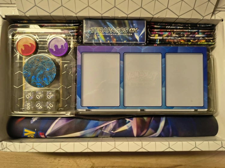 Nowy oryginalny zestaw Pokémon TCG Terapagos ex Ultra Premium Collection w języku włoskim z widocznym spisem zawartości i uszkodzonym pogniecionym kartonem
