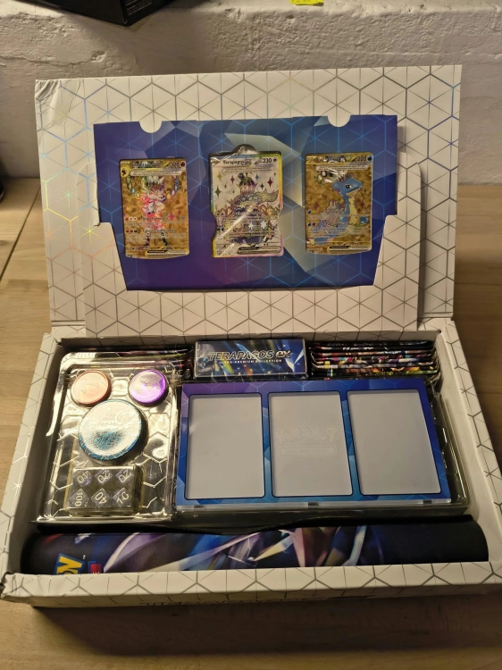 Nowy oryginalny zestaw Pokémon TCG Terapagos ex Ultra Premium Collection w języku włoskim z widocznym spisem zawartości i uszkodzonym pogniecionym kartonem