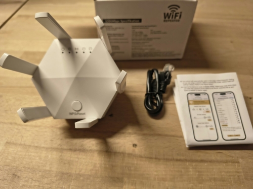 Nowy biały dwupasmowy wzmacniacz sygnału WiFi repeater AC1200 z sześcioma antenami przyciskiem WPS kablem sieciowym i instrukcją obsługi na drewnianym stole