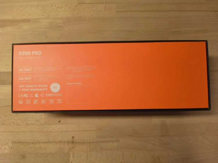 Nowy czarny wideorejestrator w lusterku WOLFBOX G900 Pro 4K rozpakowany z kompletem akcesoriów anteną GPS instrukcją i okablowaniem na drewnianym blacie