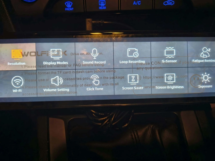Nowy czarny wideorejestrator w lusterku WOLFBOX G900 Pro 4K rozpakowany z kompletem akcesoriów anteną GPS instrukcją i okablowaniem na drewnianym blacie