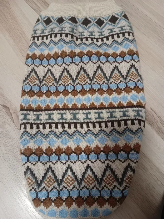 Nowy beżowy dzianinowy sweter dla psa w rozmiarze L we wzory norweskie z otworem na smycz zaprezentowany na siedzącym białym psie