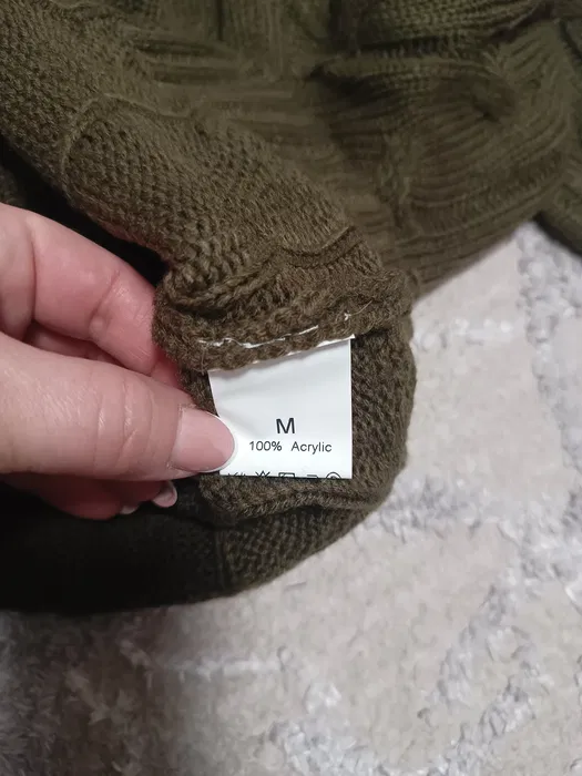 Nowy oliwkowy damski sweter z wysokim prążkowanym golfem i długim rękawem z widocznym klasycznym splotem warkoczowym na materiale