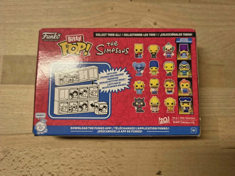 Nowy oryginalnie zapakowany zestaw czterech figurek Funko Bitty Pop The Simpsons z postaciami Scratchy Grampa Lisa i Chief Wiggum na drewnianym stole