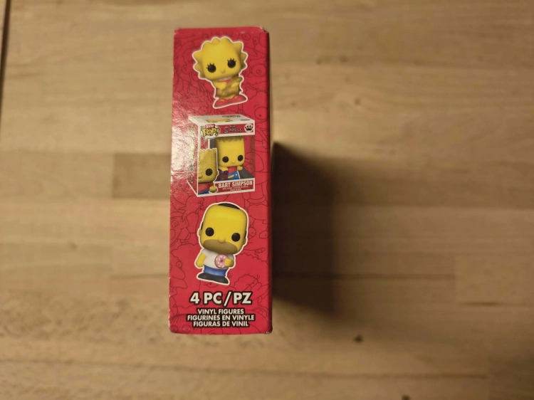 Nowy oryginalnie zapakowany zestaw czterech figurek Funko Bitty Pop The Simpsons z postaciami Scratchy Grampa Lisa i Chief Wiggum na drewnianym stole