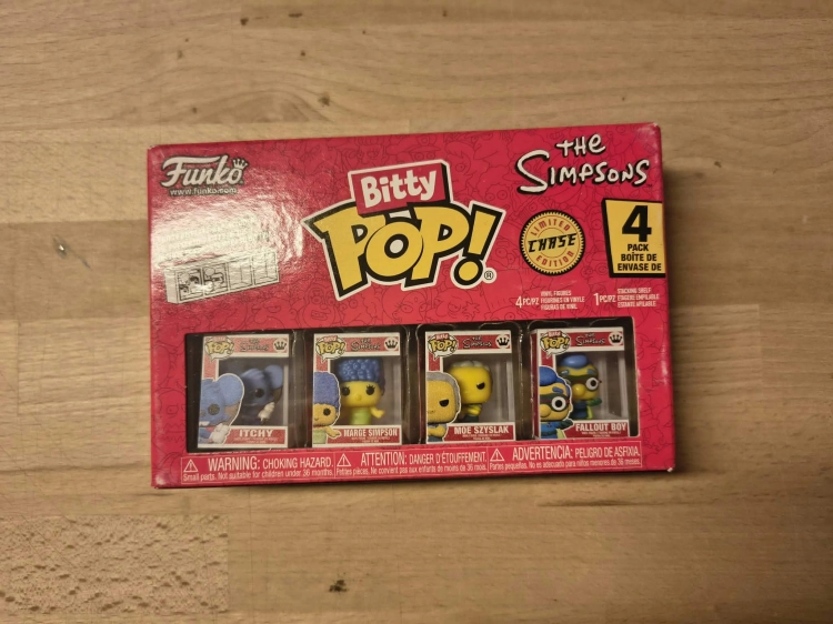 Nowy oryginalnie zapakowany kolekcjonerski zestaw czterech minifigurek Funko Bitty Pop The Simpsons z postaciami Itchy Marge Moe i Fallout Boy na drewnianym blacie